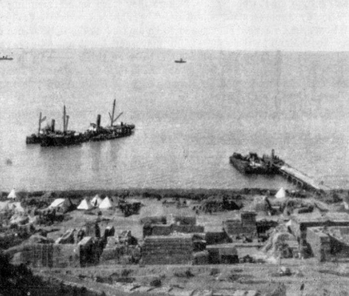 William's Pier - where the 28th landed. Stores in the foreground. The vessel on the left was sunk to act as a breakwater and afterwards used as a reservoir for drinking water. Trawlers in the distance. Photo. lent by Mr. T. Pritchard.