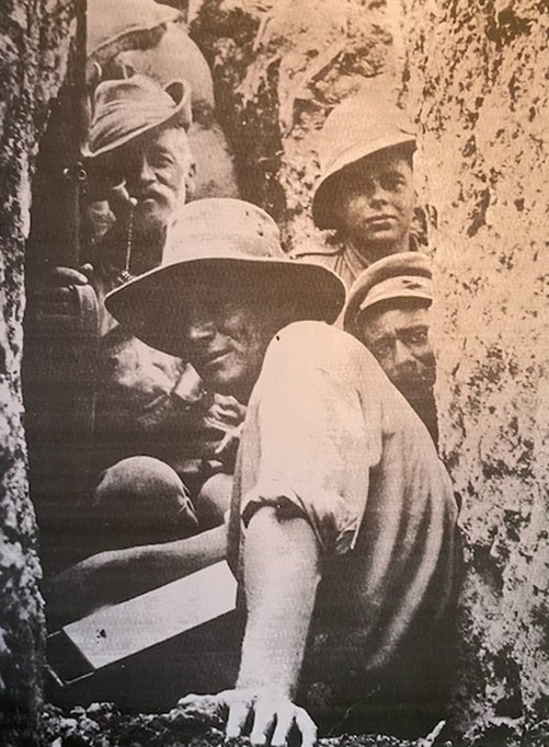 Australian father (smoking pipe) and son (in front) serving together in the trenches on Walker’s Ridge, Gallipoli. Personal photograph, H.V.Woods HU 53364