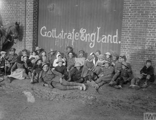 IWM Q 1904: British troops with French children in the village of Vraignes  (Vraignes-en-Vermandois), 20th March 1917.