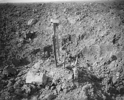 Battle of Morval. A makeshift grave in a shell-hole, marked by an inverted rifle driven into the ground near Combles. © IWM Q 4316