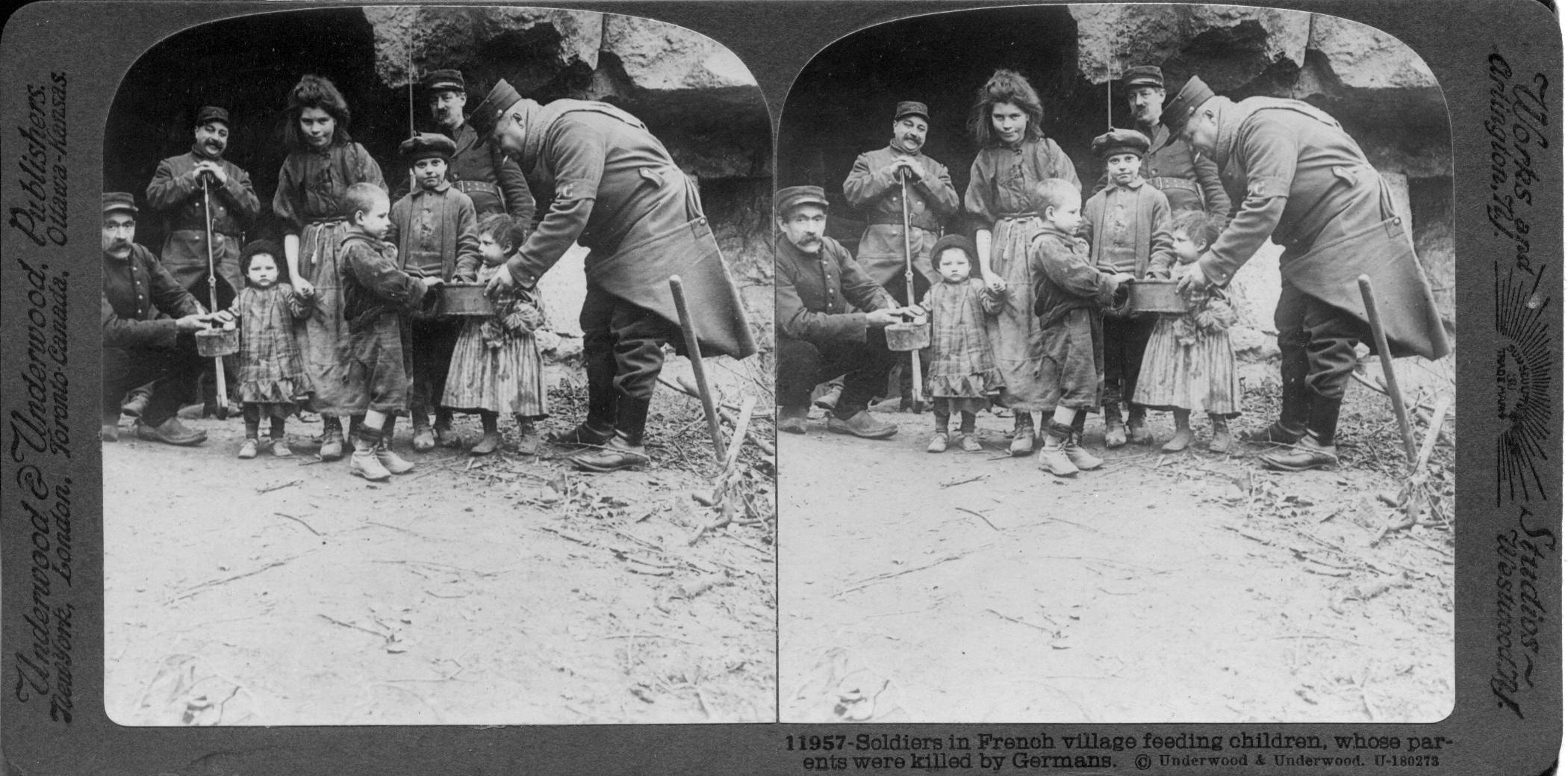 Soldiers in French village feeding children, whose parents were killed by Germans