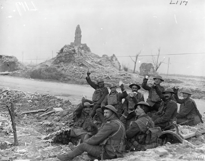 Men of a pioneer battalion of the West Yorkshire Regiment, possibly 21st (Service) Battalion (Wool Textile Pioneers), having a meal in a shell hole on the roadside near Ypres, 23 December 1917. © IWM Q 8441