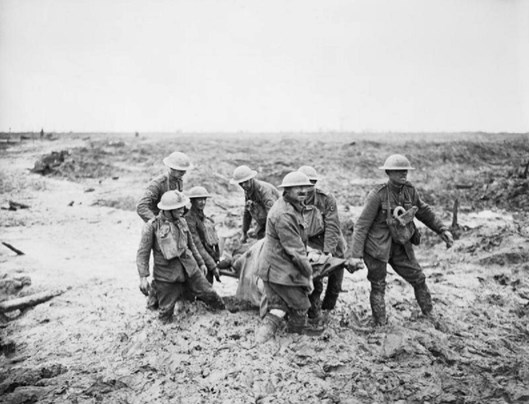 Stretcher bearers struggle in mud up to their knees to carry a wounded man to safety near Boesinghe on 1 August. Q 5935.