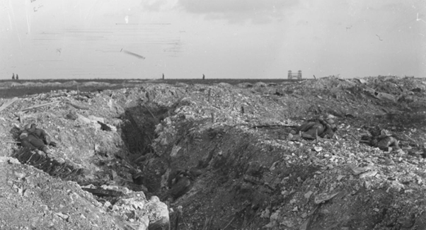 Battle of Loos, 25th September, 1915. British dead in front of a captured German trench; near Loos, 30th September, 1915. The towers of Loos can be seen in the distance. © IWM Q 28980