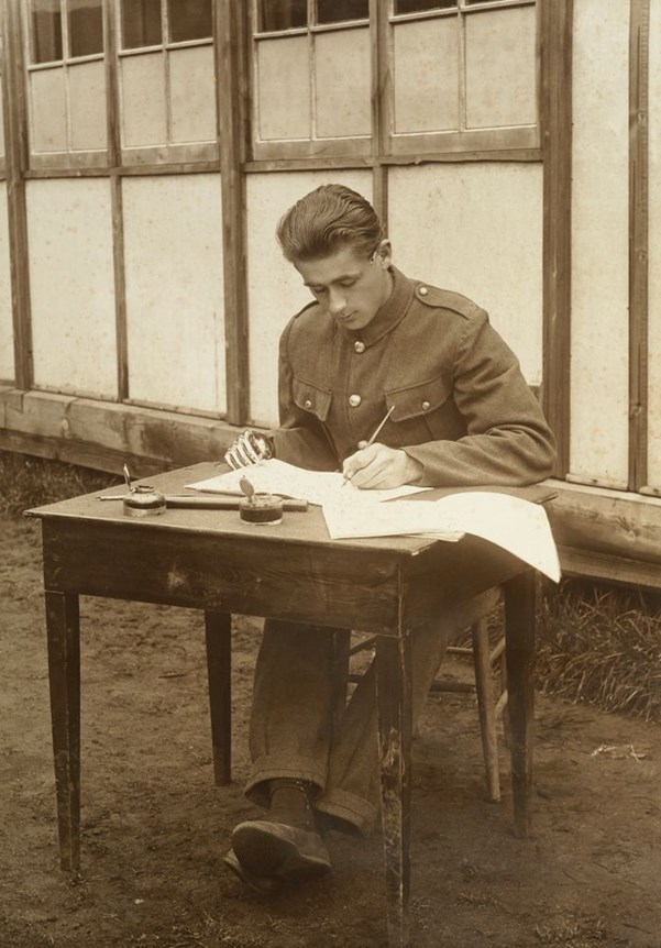 Unidentified WWI soldier with a prosthetic right hand learning to write with his left. Photographs, Collection, Te Papa Tongarewa, Wellington, New Zealand.