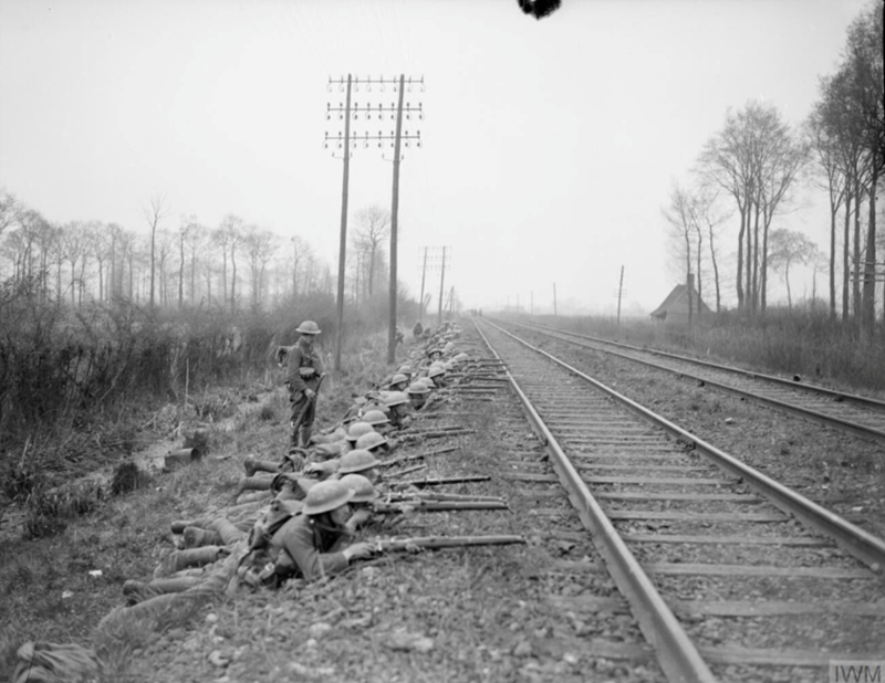 Battle of Hazebrouck. Collected stragglers of the 31st Division lining the railway line near Merris, 12 April 1918. (c) IWM Q 8688