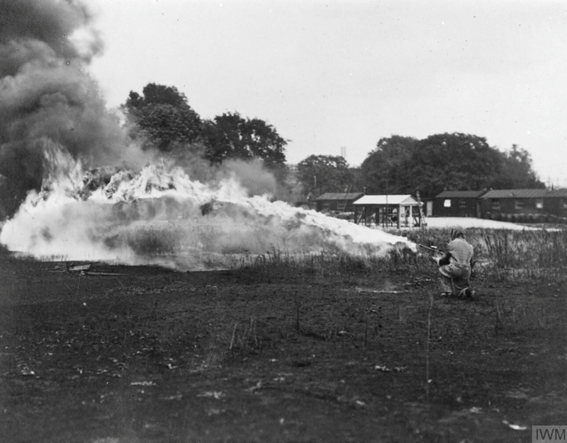 Hay Flame gun in action; operator wearing protective clothing. IWM Q64218