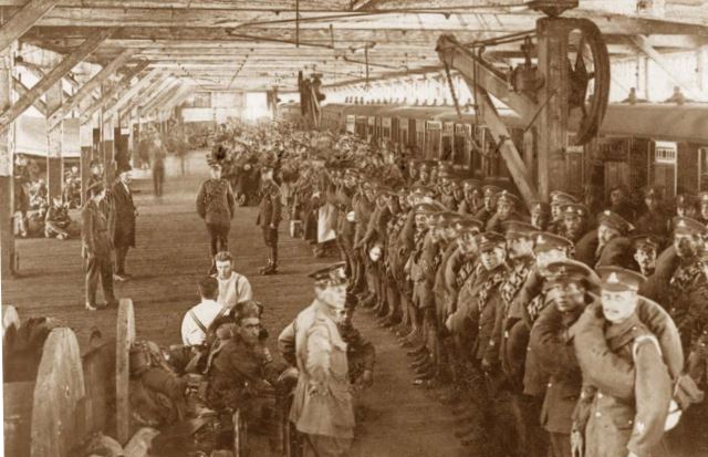 Troops in a dockside shed waiting to board their ship