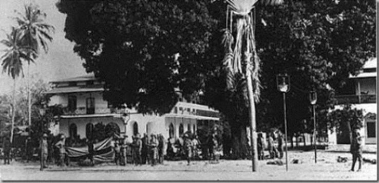 Schutztruppe Soldiers Posing With A Captured British Flag In Front Of The Casino Of Tanga.