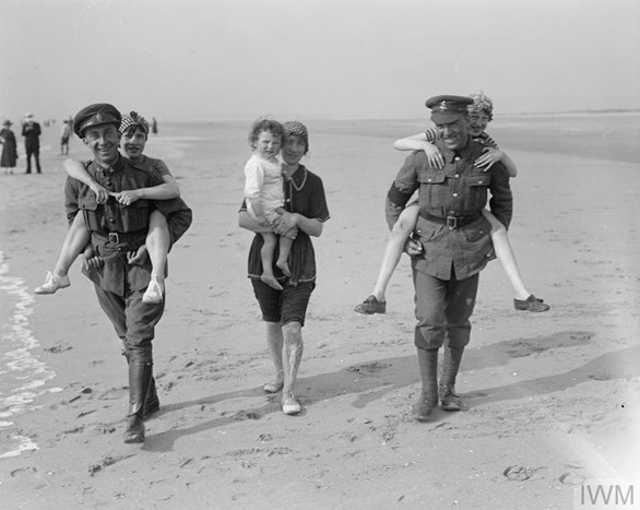 British Soldiers Giving A Piggyback To French Children On The Beach At Paris Plage While On Leave, 18 May 1918. (IWM Q 11483