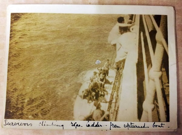 Survivors Climbing Rope Ladder From Upturned Boat.