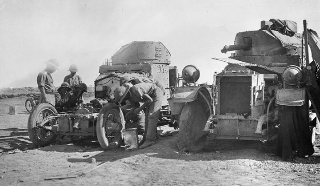 A repair team works on a British armoured car