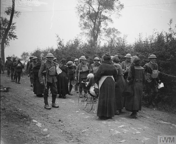 Men Of The Going Forward And Belgian Refugee Women Going Back. Gullegem, Near Heule, 15 October 1918. © IWM Q 7120
